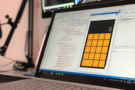 A laptop screen with a window of code and a calculator